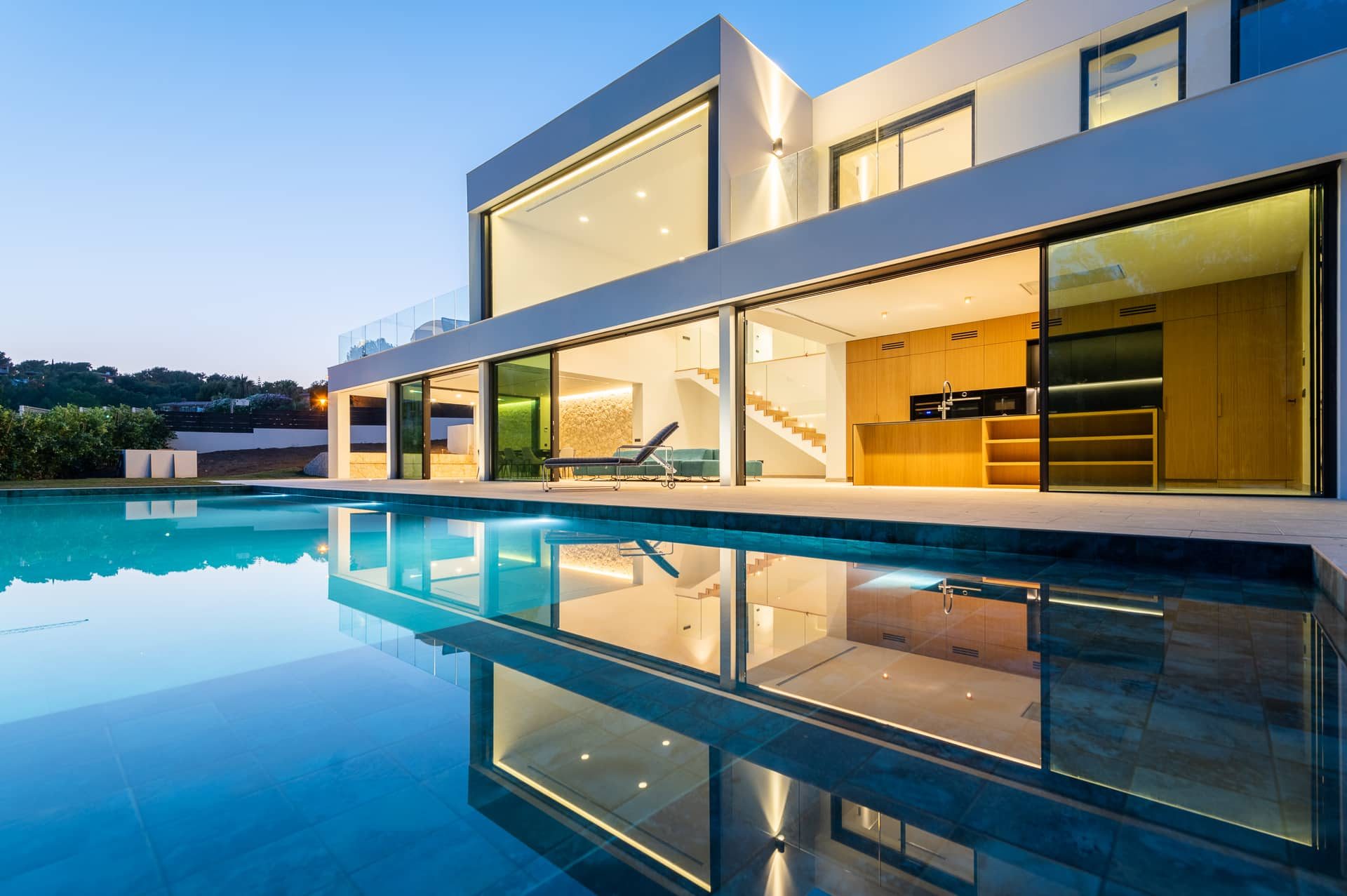 Construcción de piscinas en Mallorca: piscina de obra a medida junto a una villa, al atardecer