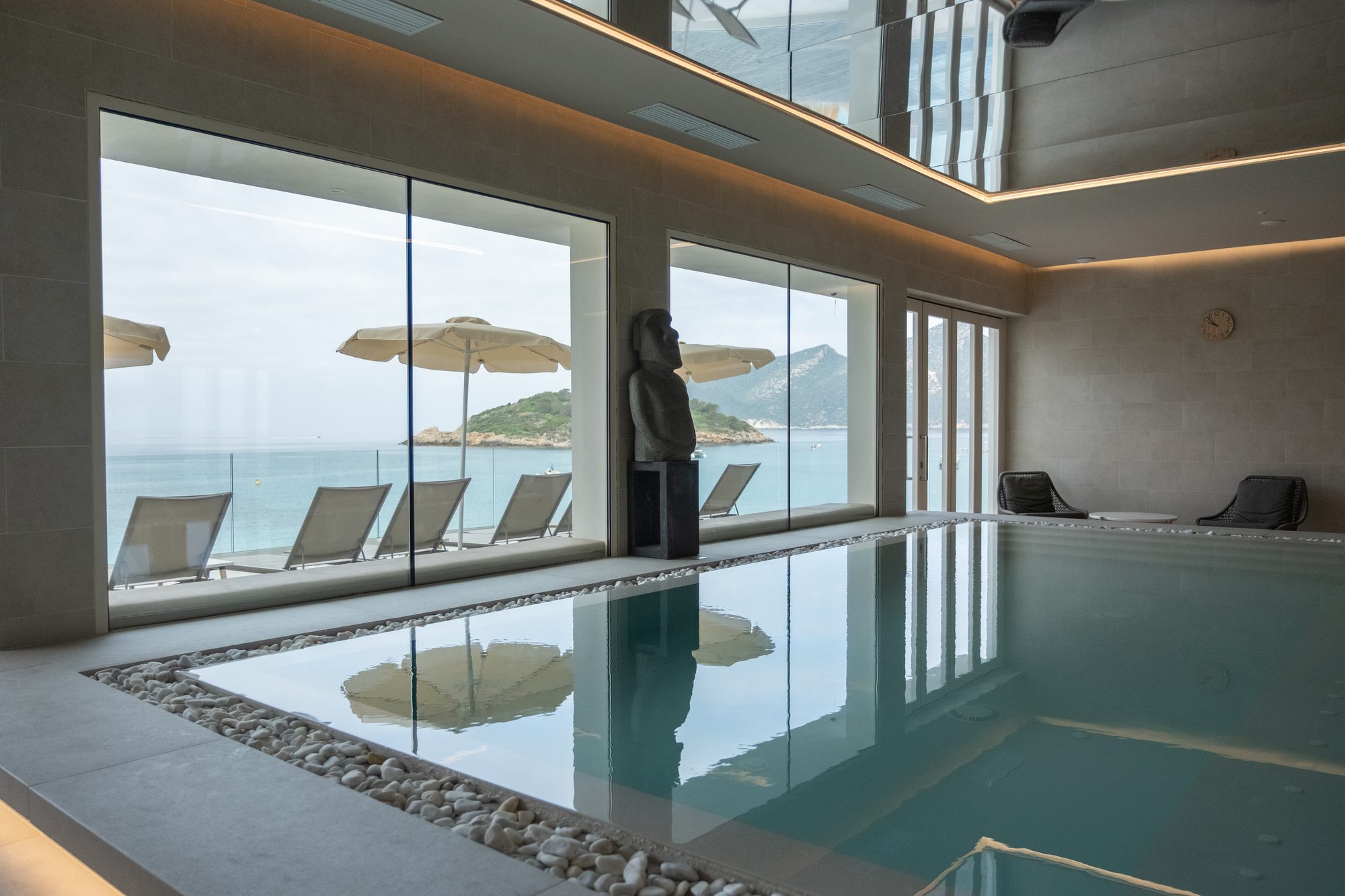 Piscina interior junto a los ventanales con vistas al mar de Sant Elm