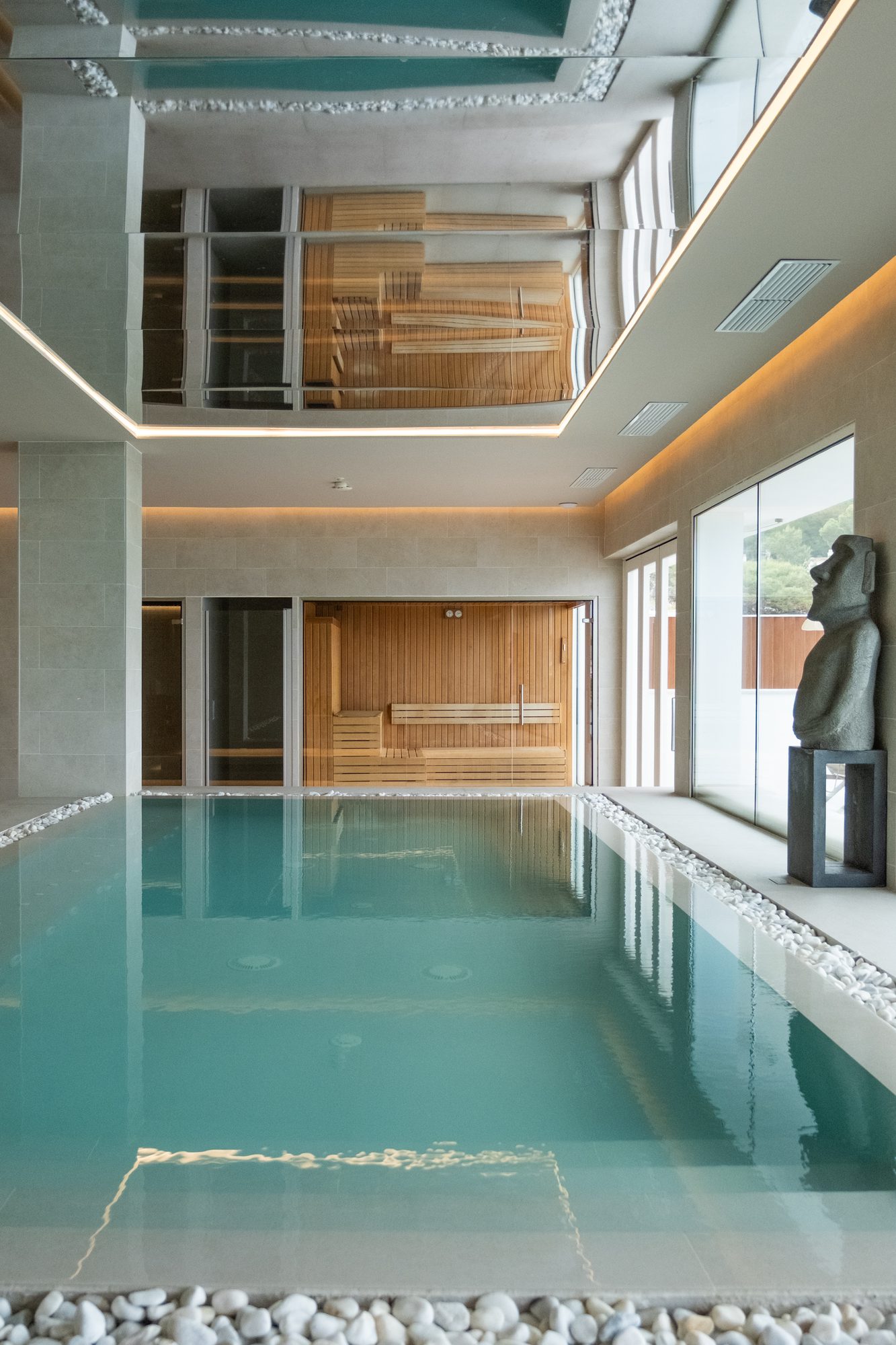 Vaso de agua turquesa con canto rodado y piedra natural en el spa del hotel